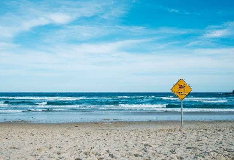 plage avec un panneau qui signale interdit de se baigner.