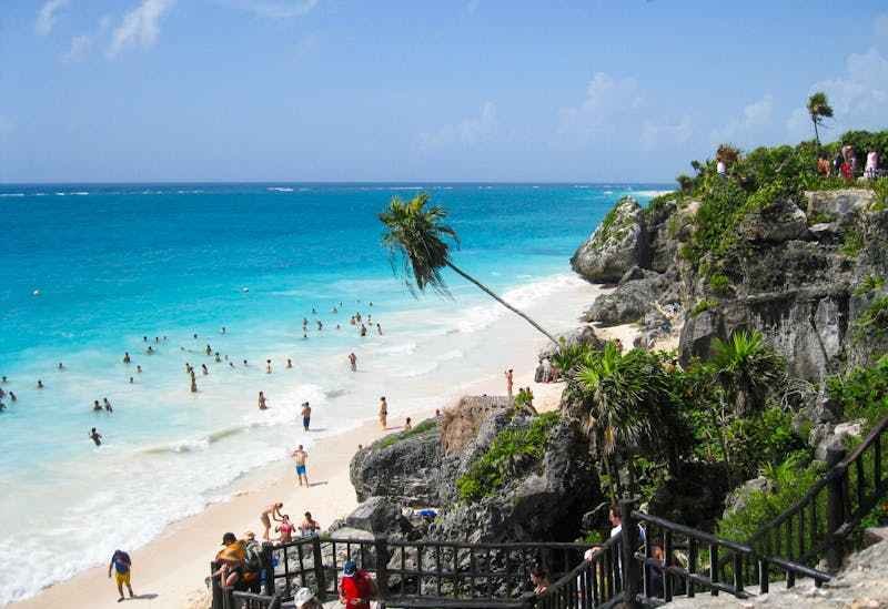 Des touristes sont sur la plage et dans l'eau à Saint-Francois en Guadeloupe.