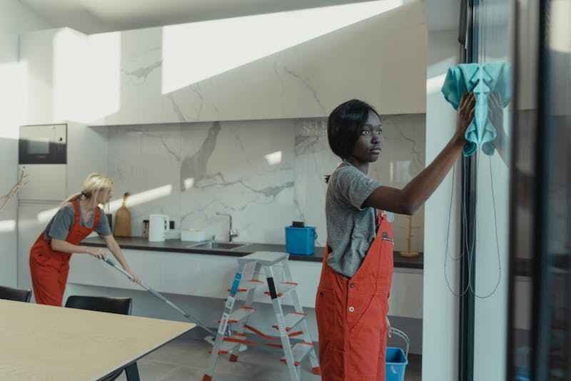 conciergerie-saint-francois-guadeloupe Deux femmes habillées pareil, qui travaillent pour une conciergerienettoient un appartement.